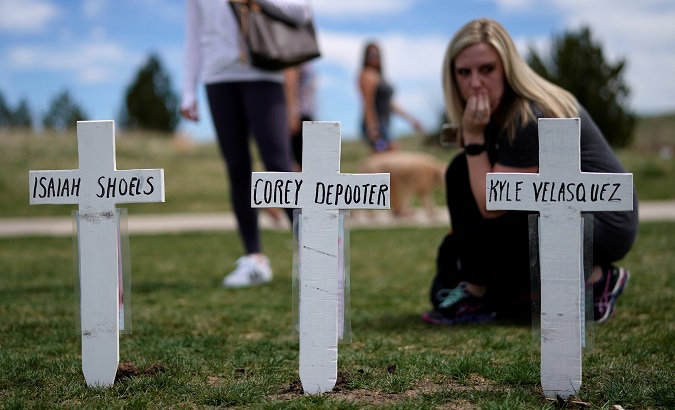 Cassanda Sadusky, survivor of the attack, looks at a line of crosses commemorating those killed in the Columbine High School shooting on the 20th anniversary of the attack in Littleton, Colorado, U.S., April 20, 2019