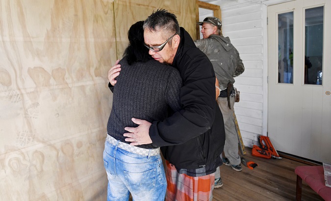 Abdul Aziz, who has been hailed as hero for chasing shooter away, hugs a friend as they help to renovate the Linwood Mosque in Christchurch, New Zealand.