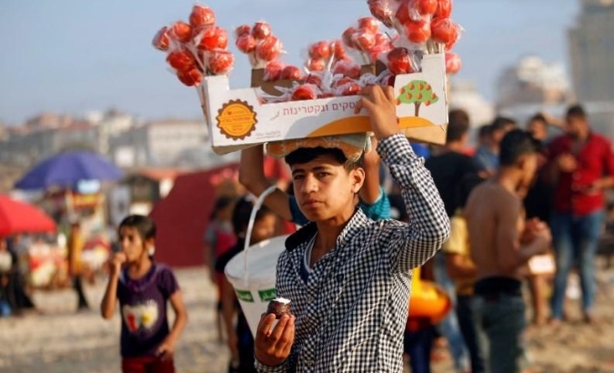 A Palestinian vendor sells sweets along the beach in a warm weather in Gaza City.