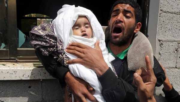 Relative of 14-month old Palestinian baby Seba Abu Arar carries her body during her funeral in Gaza City