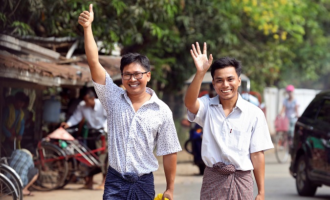 Reuters reporters Wa Lone and Kyaw Soe Oo gesture as they walk to Insein prison gate after being freed, after receiving a presidential pardon in Yangon, Myanmar, May 7, 2019.