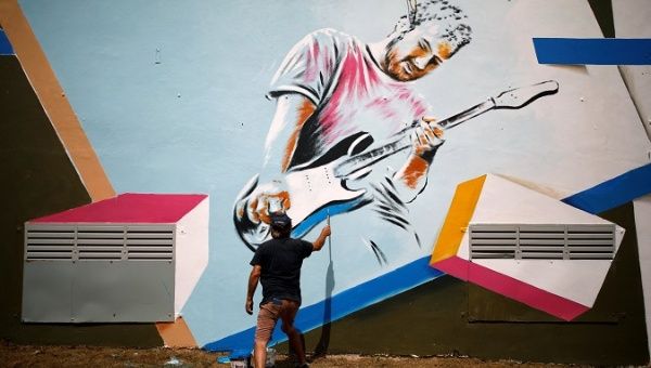 A man paints a mural on a structure that is located close to where the Eurovision Village, a space dedicated of fans of the upcoming Eurovision Song Contest, is being constructed in Tel Aviv, Israel May 6, 2019.