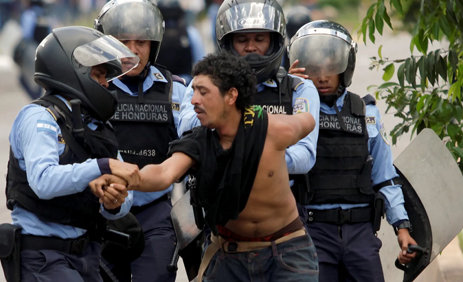 Four National Police members in Honduras drag away demonstrator against the Hernandez administration