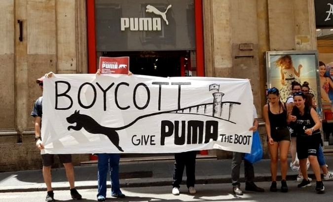 Pro-Palestine activists protest outside a Puma store.