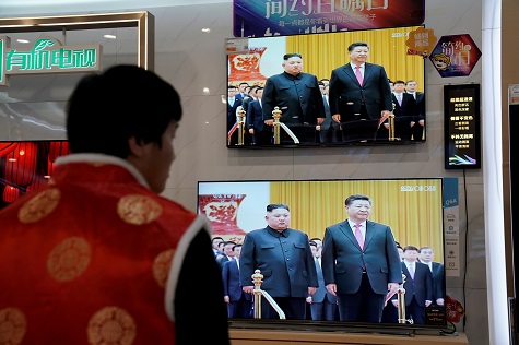 Television screens show Chinese state media CCTV's footage of North Korean leader Kim Jong Un's meeting with Chinese President Xi Jinping, at an electronics store in Beijing