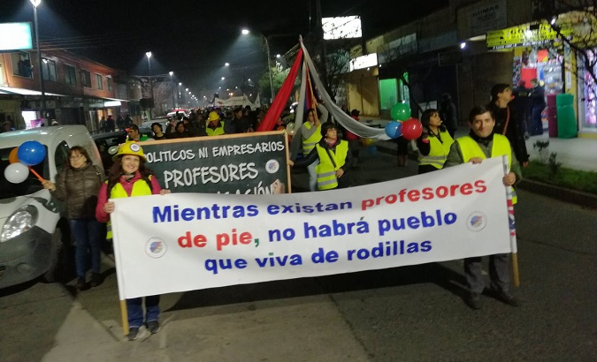 Protesters holding a banner that reads 'As long as teachers stand up, the people will not be on their knees' in Osorno, Chile, June 20, 2019.