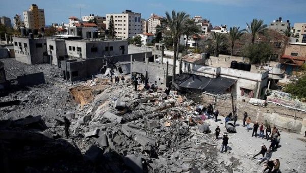 Palestinians inspect a destroyed Hamas site after it was targeted by an Israeli air strike in Gaza.