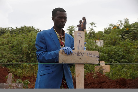 A Congolese man holds a cross during the burial service of Congolese woman Kahambu Tulirwaho who died of Ebola, at a cemetery in Butembo.