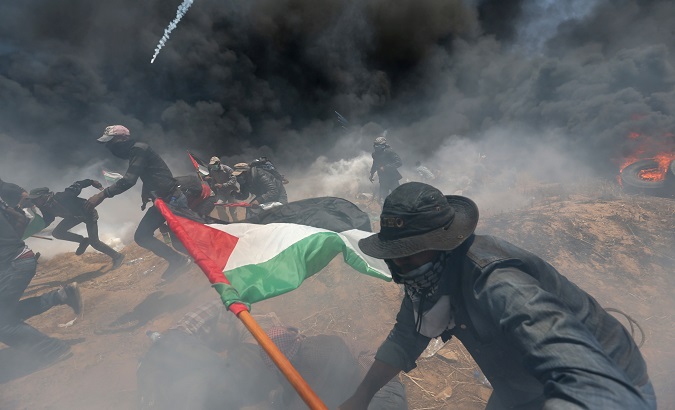 Palestinian demonstrators run for cover from Israeli fire and tear gas during a protest.
