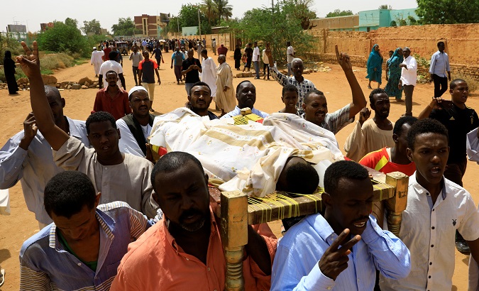 Locals and relatives of three Sudanese men riddled with bullets chant slogans as they carry one of the corpses in the city of Omdurman across the River Nile from Khartoum, Sudan, July 1, 2019.