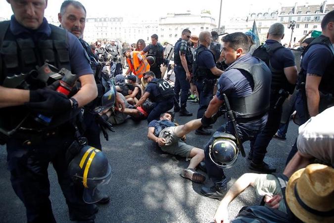 French CRS riot police remove French youth and environmental activists as they block a bridge during a demonstration to urge world leaders to act against climate change, in Paris, France, June 28, 2019.