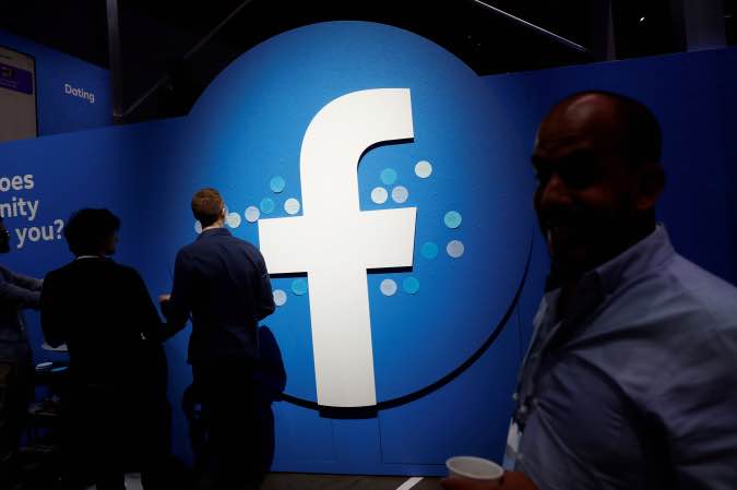 Attendees walk past a Facebook logo in San Jose, California, U.S., April 30, 2019.