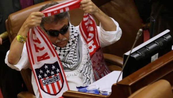 Former commander of Colombia's Marxist Revolutionary Alternative Force of the Common (FARC) Jesus Santrich dresses a scarf of Colombian Atletico Junior soccer team in a plenary session at the congress in Bogota