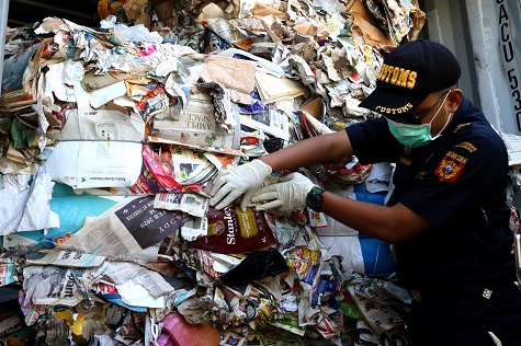 A customs officer shows a container of waste paper imported from Australia. Surabaya, East Java province. July 9, 2019