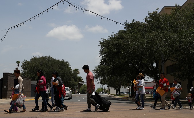Migrants walk to a respite center after being released from detention in McAllen, Texas, U.S., July 4, 2018.