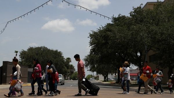 Migrants walk to a respite center after being released from detention in McAllen, Texas, U.S., July 4, 2018.