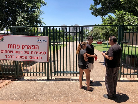 A security guard checks the identification of visitors near the entrance to a park in the northern Israeli town of Afula.