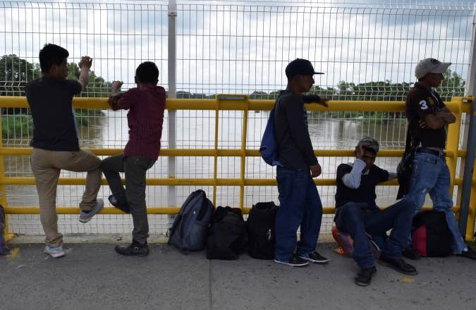 Migrants queue to request humanitarian visas to enter Mexico at the Rodolfo Robles international border crossing bridge,