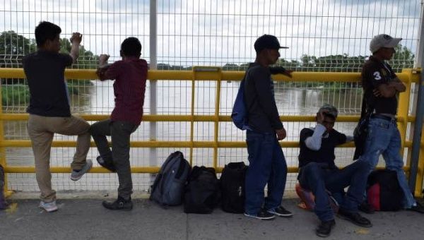 Migrants queue to request humanitarian visas to enter Mexico at the Rodolfo Robles international border crossing bridge,