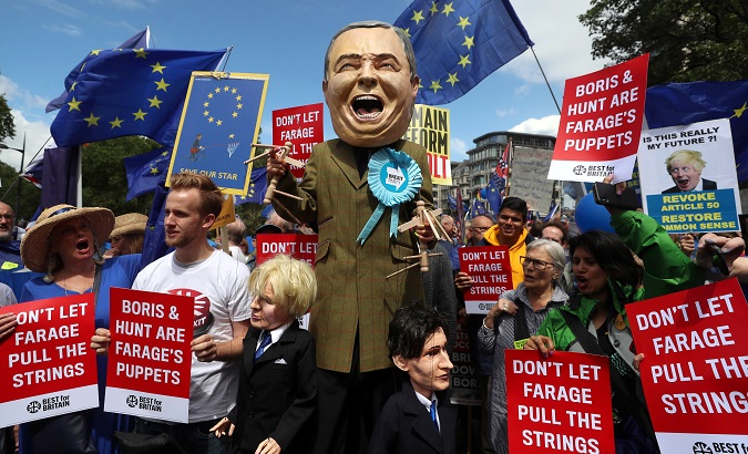 Person dressed as Brexit Party leader Nigel Farage holds puppets depicting Boris Johnson and Jeremy Hunt in London, Britain July 20,2019.