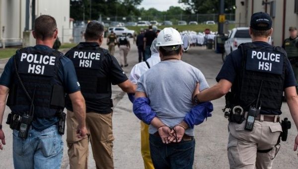 Special agents with Homeland Security Investigations, the investigative arm of U.S. Immigration and Customs Enforcement, lead a man away from Fresh Mark in Salem, Ohio, on Tuesday.