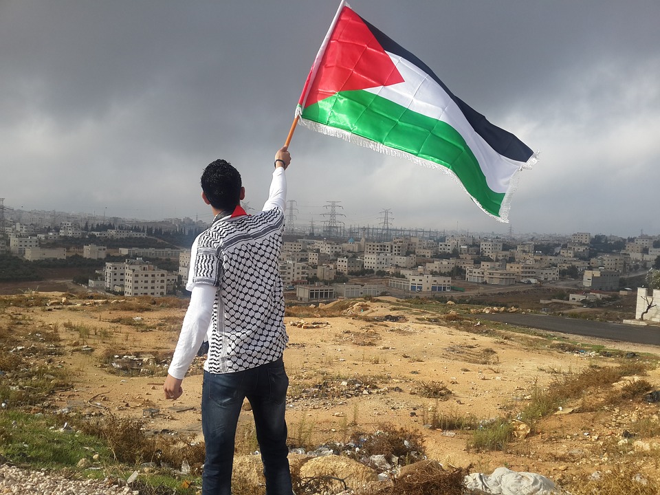 Palestinian raising the country's flag