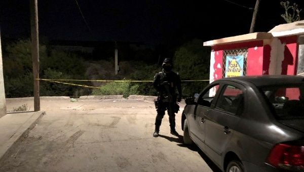 Police officer keeps watch at a scene after a migrant was gunned down in Saltillo, Mexico, July 31, 2019.