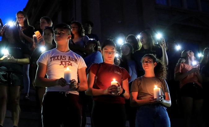 Samuel Lerma, Arzetta Hodges and Desiree Qunitana join mourners taking part in a vigil at El Paso High School after a mass shooting at a Walmart store in El Paso, Texas, U.S. August 3, 2019.