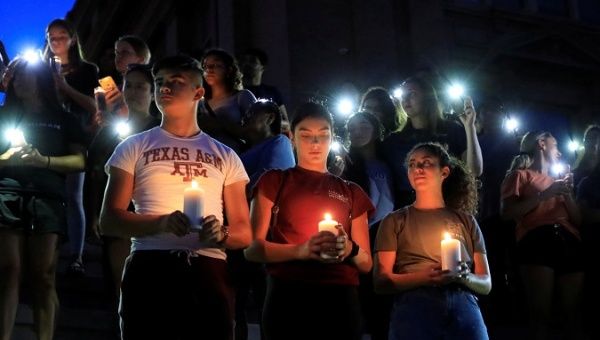 Samuel Lerma, Arzetta Hodges and Desiree Qunitana join mourners taking part in a vigil at El Paso High School after a mass shooting at a Walmart store in El Paso, Texas, U.S. August 3, 2019. 