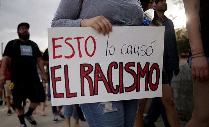 People take part in a rally against hate a day after a mass shooting at a Walmart store, in El Paso, Texas, The placard reads, 