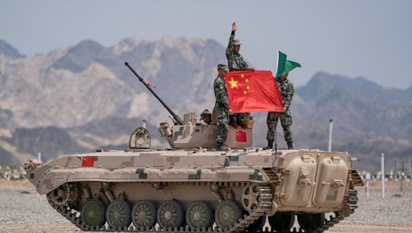 Chinese soldiers of People's Liberation Army (PLA) pose for photos with a Chinese national flag on a tank during the Suvorov Attack contest of the International Army Games 2019 in Korla, Xinjiang Uighur Autonomous Region, China August 4, 2019.