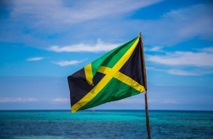 Flag of Jamaica waving over the Caribbean Sea.