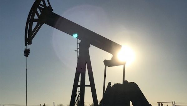 An oil rig drilling a well at sunrise near Midland, Texas.