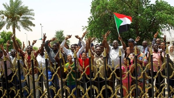 Sudanese people carry their national flag and chant slogans as they celebrate the signing of a constitutional declaration between Deputy Head of Sudanese Transitional Military Council, Mohamed Hamdan Dagalo and Sudan's opposition alliance coalition's leader Ahmad al-Rabiah, outside the Friendship Hall, in Khartoum, Sudan August 4, 2019. 