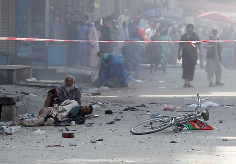 Wounded men lay on the ground as they wait transfer to the hospital, after a blast in Jalalabad.