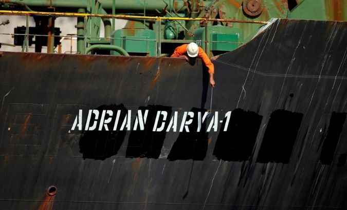 A crew member takes pictures with a mobile phone to Iranian oil tanker Adrian Darya 1, before being named as Grace 1.