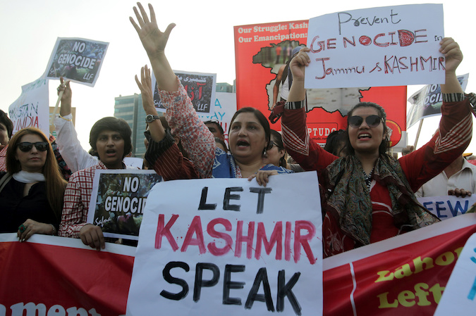 People carry signs as they chant slogans to express solidarity with the people of Kashmir, during a rally in Lahore, Pakistan, August 20, 2019.