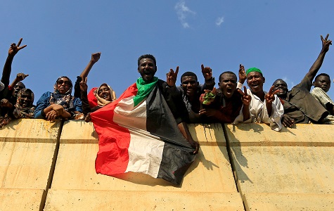 Civilians hold their national flag as they celebrate the signing of the Sudan's power sharing deal, in Khartoum.