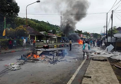 Protesters set on fire the local parliament building and cars during a protest against the detention of Papuan students.