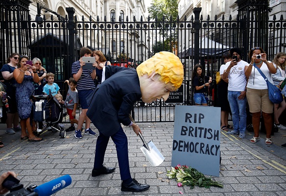A man wearing a mask of Boris Johnson protests outside Downing Street in London, Britain August 28, 2019.