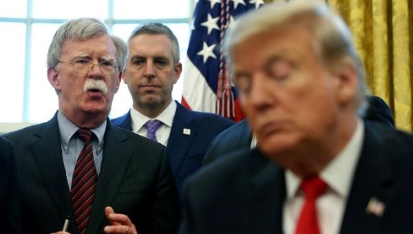 U.S. President Donald Trump listens as his national security adviser John Bolton speaks during an event at the White House.