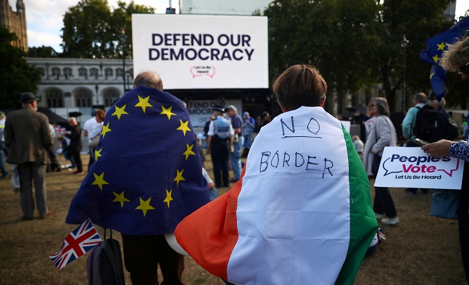 Woman wearing an Irish flag and man wearing an EU flag demonstrate in front of the Parliament in London, Britain, Sep. 4, 2019.