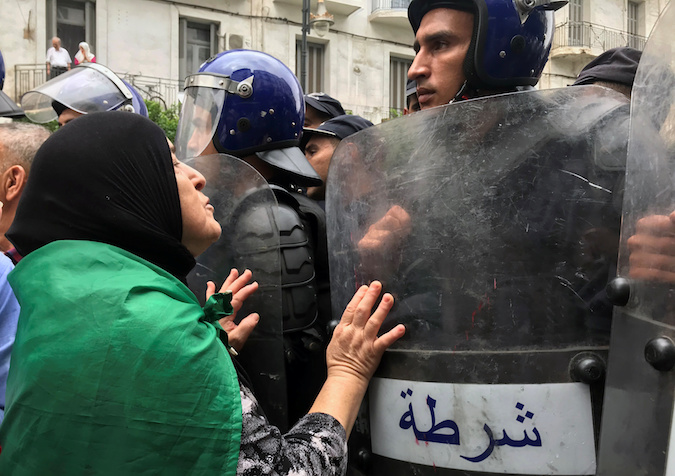 A demonstrator approaches police officers during a protest demanding the removal of the ruling elite in Algiers, Algeria September 13, 2019.