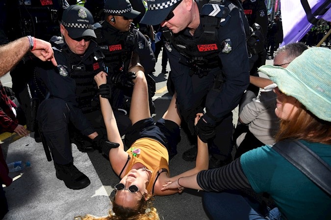 Climate change activist is removed by Police during a demonstration on Princes Bridge in Melbourne, Australia, Sep. 14, 2019.
