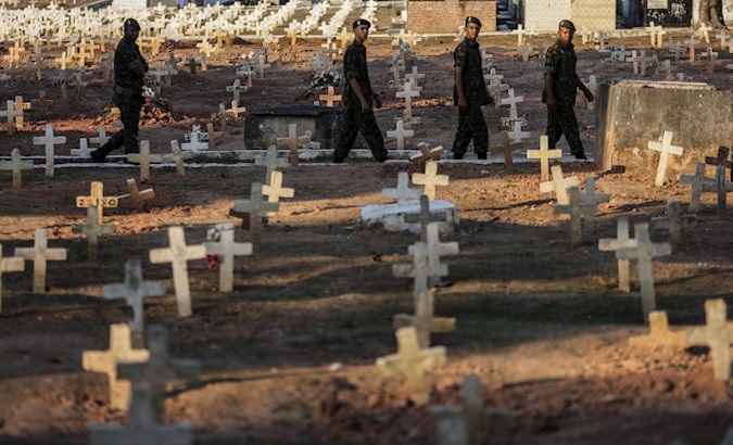 Members of Brazilian security forces cross a cemetery located at an urban poor neighborhood, Brazil, Sep. 10, 2019.