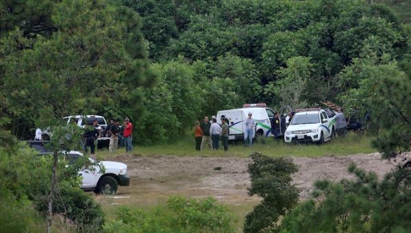 Forensic vehicles and government officials near a clandestine grave in the municipality of Zapopan, outskirts of Guadalajara September 18, 2019.