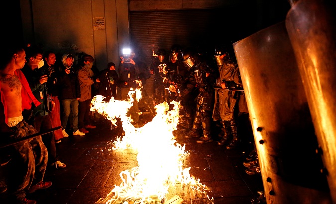 Pro-abortion protesters face riot police in Quito, Ecuador, Sep. 20, 2019.