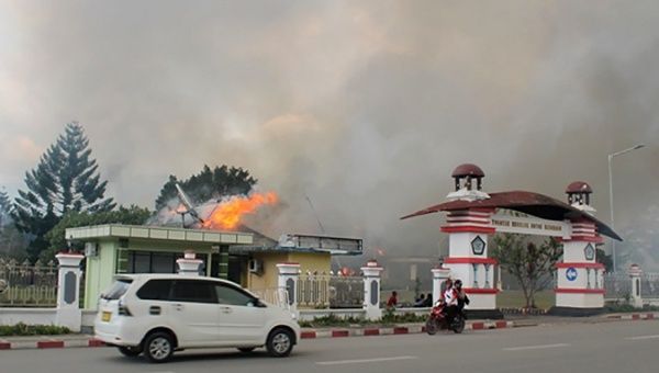 A car passes governor office building of Jayawijaya burned during a protest in Wamena, Papua, Indonesia, September 23, 2019.