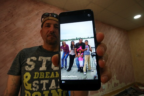Hani al-Bazoni, who was deported from the U.S. to Iraq under Donald Trump's strengthened immigration enforcement, shows a picture of his family.