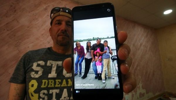 Hani al-Bazoni, who was deported from the U.S. to Iraq under Donald Trump's strengthened immigration enforcement, shows a picture of his family.